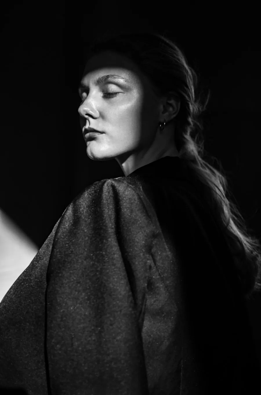 Dark sculptural outerwear portrait